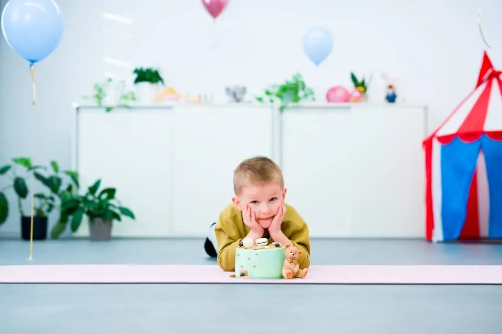 dziecko z tortem na sali zabaw